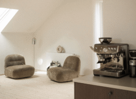 Zwei Sessel mit Stehlampe, Kaffeemaschine in Küchenzeile im Vordergrund