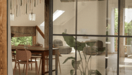 Blick durch Glasscheibe in hellen Raum mit zeitgenössischen Möbeln 